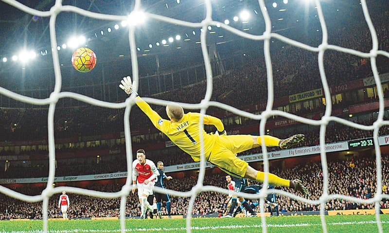 LONDON Arsenal’s Theo Walcott watches his shot beat Manchester City’s goalkeeper Joe Hart as he scores his team’s first goal during their English Premier League match at the Emirates Stadium.—Reuters