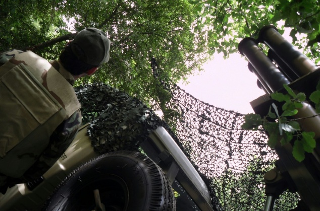 A Hezbollah fighter stands beside a rocket launcher in southern Lebanon