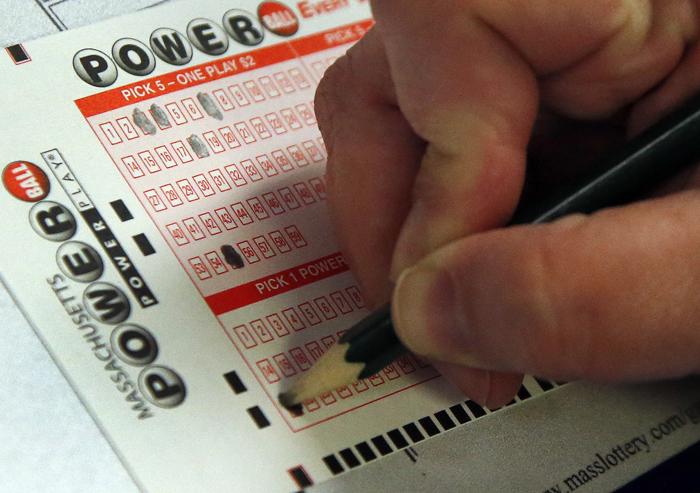 A customer fills out her Powerball lottery ticket at a convenience store in North Andover Mass. Wednesday Feb. 19 2014. The estimated Powerball jackpot is $400 million