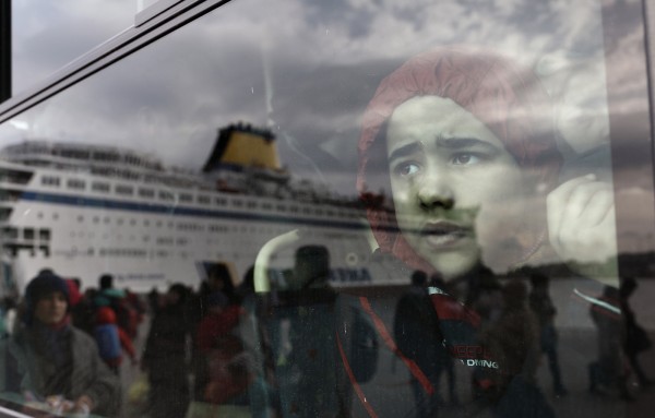 A refugee boy looks out of a bus after arriving at the port of Piraeus near Athens Greece