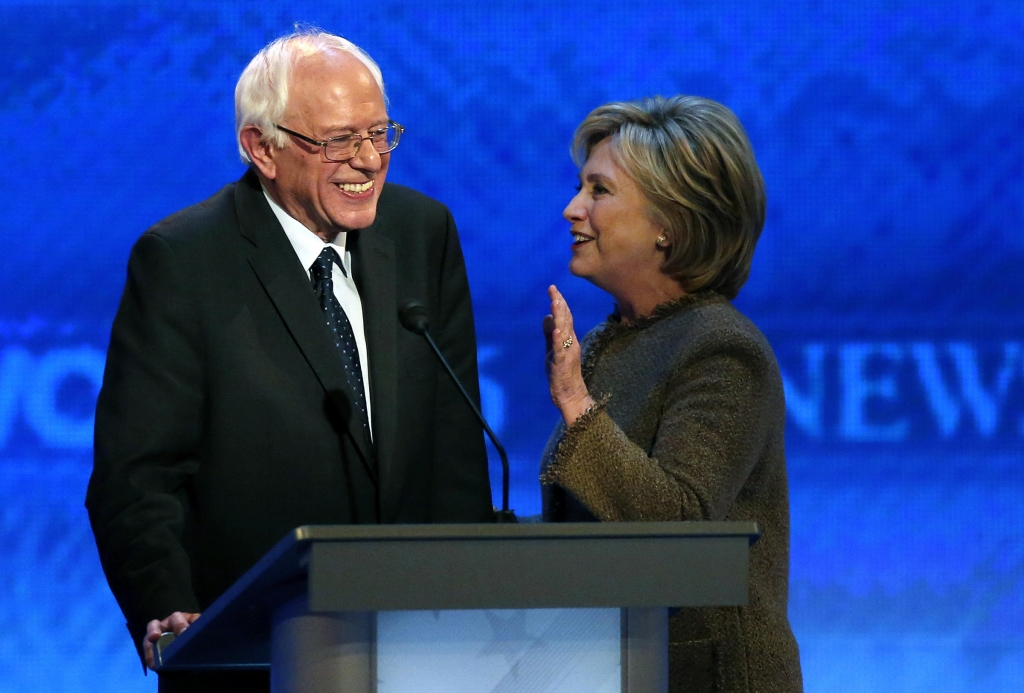 Hillary Clinton right speaks to Bernie Sanders during a break at the Democratic presidential primary debate Saturday Dec. 19 2015 at Saint Anselm College in Manchester N.H