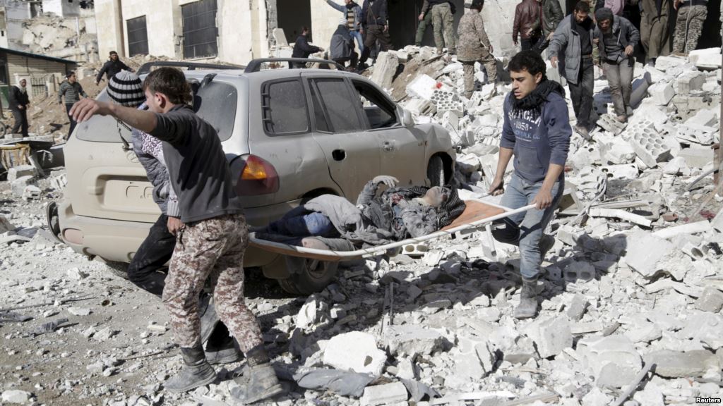 Residents carry an injured woman on a stretcher in a site hit by airstrikes in the rebel-controlled area of Maarat al Numan town in Idlib province Syria Jan. 9 2016