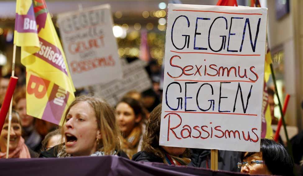 Women shout slogans and hold up a placard that reads'Against Sexism- Against Racism as they march through the main railways station of Cologne Germany on January 5