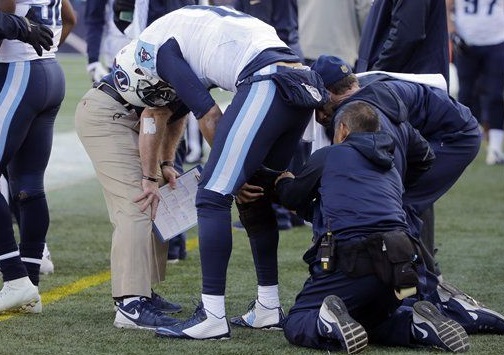 Tennessee Titans quarterback Marcus Mariota has a knee brace fitted on the sideline in the first half of an NFL football game against the New England Patriots Sunday Dec. 20 2015 in Foxborough Mass. Mariota did not return to the game. (AP