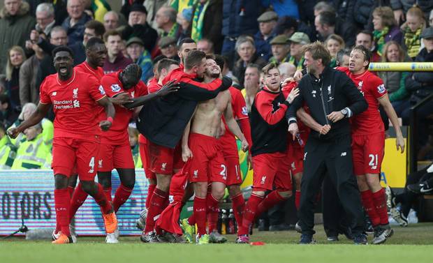 Adam Lallana celebrates with team mates and manager Jurgen Klopp after scoring the winning goal for Liverpool against Norwich on Saturday