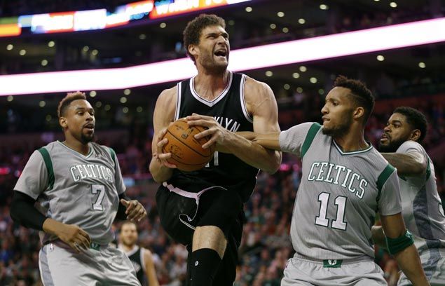 Brooklyn Nets Brook Lopez center drives for the basket between Boston Celtics Jared Sullinger and Evan Turner during the third quarter of an NBA basketball game in Boston Saturday Jan. 2 2016. The Nets won 100-97. AP