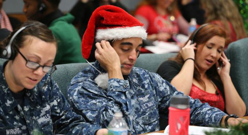 Santa tracker volunteers take phone calls from children asking where Santa is and when he will deliver presents to their homes inside a phone-in center during the annual NORAD Tracks Santa Operation at the North American Aerospace Defense Command at Pe