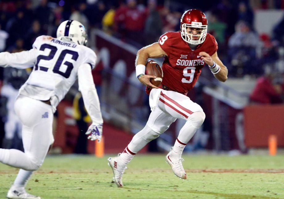 Oklahoma quarterback Trevor Knight runs as TCU safety Derrick Kindred closes in during the fourth quarter of an NCAA college football game in Norman Okla. Saturday Nov. 21 2015. Oklahoma won 30-29