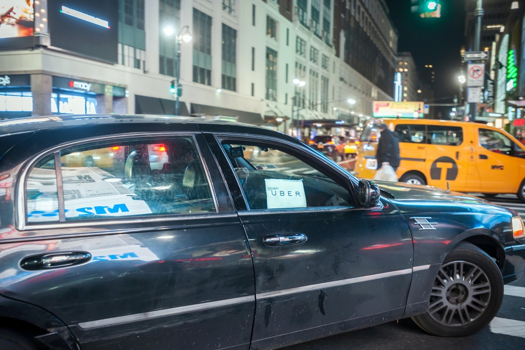 An Uber livery travels through Midtown Manhattan in New York