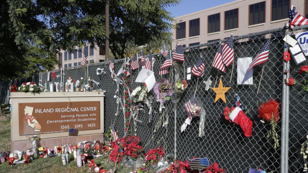 FILE- Flowers and American flags honoring the victims of the Dec. 2 2015 terror attack at the Inland Regional Center are seen outside the complex in San Bernardino California Dec. 29 2015