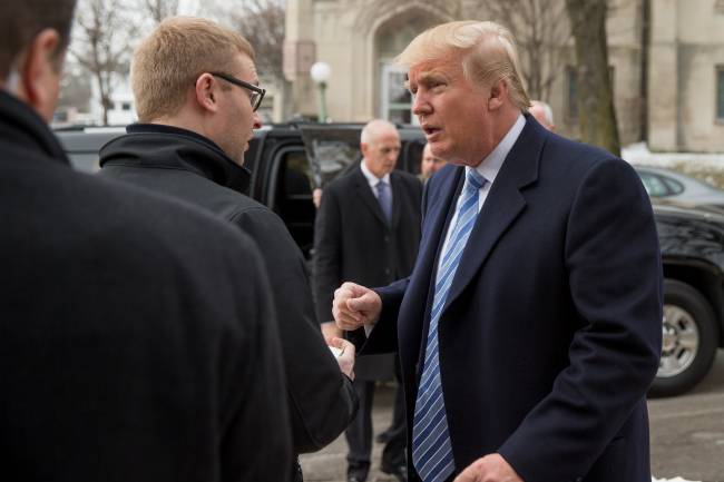 Republican presidential candidate Donald Trump signs an autograph as he arrives for service at First Presbyterian Church in Muscatine Iowa Sunday Jan. 24 2016