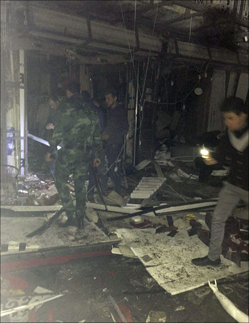 Iraqi security forces inspect the scene of the attack at a mall in Baghdad Iraq today. Gunmen stormed into a Baghdad mall on Monday after setting off a car bomb and launching a suicide attack at its entrance