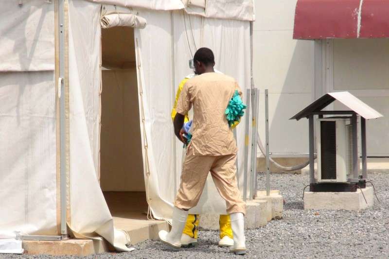 A health worker enters a tent in an Ebola virus treatment center in Conakry Guinea