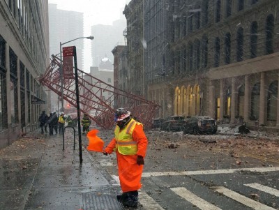 One dead and several trapped as crane topples in New York street