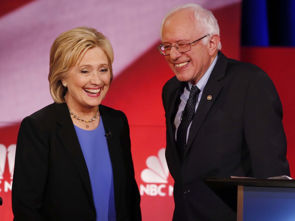 Democratic presidential candidates Hillary Clinton and Sen. Bernie Sanders smile during a break of the Democratic presidential debate on Jan. 17 2016