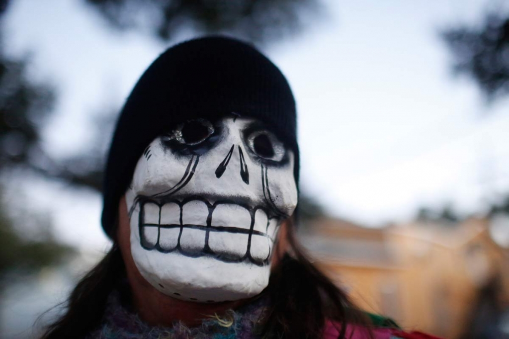 A parade-goer walks the streets with the North Side Skull & Bone Gang during the wake up call for Mardi Gras Tuesday Feb. 9 2016 in New Orleans