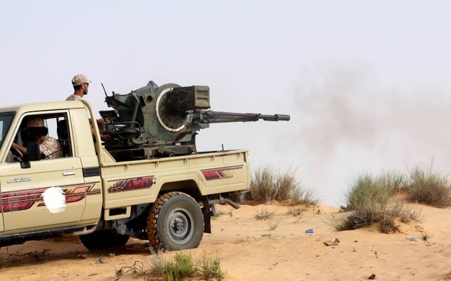 Fighters from the Fajr Libya militia sit in the back of an armed pick-up truck during clashes southwest of Sabratha