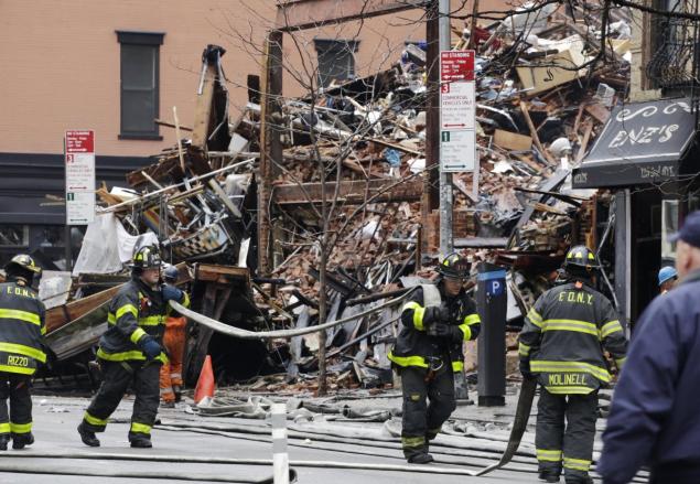 Firefighters roll up fire hoses at the site of March 2015’s East Village explosion