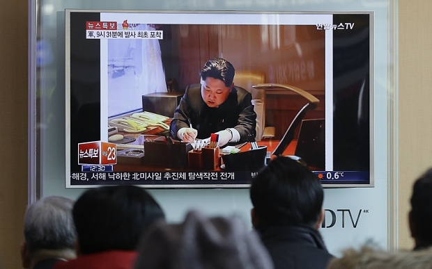 People watch a TV news program showing an image of North Korean leader Kim Jong Un in Seoul