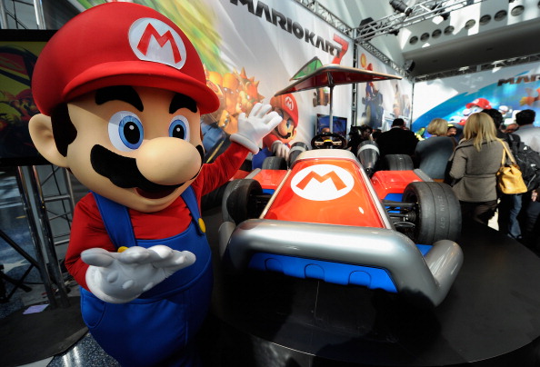 Nintendo game character Mario stands next to the new gamer-themed car built by West Coast Customs