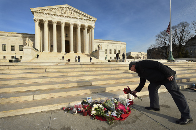 James Peck of Springfield Virginia lays flowers down at a makeshift memorial for Supreme Court Justice Antonin Scalia on Sunday