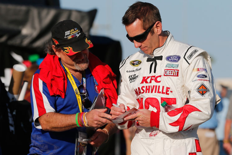 DAYTONA BEACH FL- FEBRUARY 17 Greg Biffle driver of the #16 KFC Nashville Hot Ford signs an autograph during practice for the Daytona 500 at Daytona International Speedway