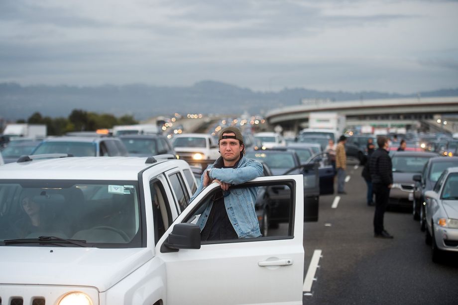 Motorists stand outside their vehicles as protesters block traffic on the San Francisco Oakland Bay Bridge on Monday Jan. 18 2016 in San Francisco. A group of protesters from the group Black Lives Matter caused the shutdown of one side of the bridge