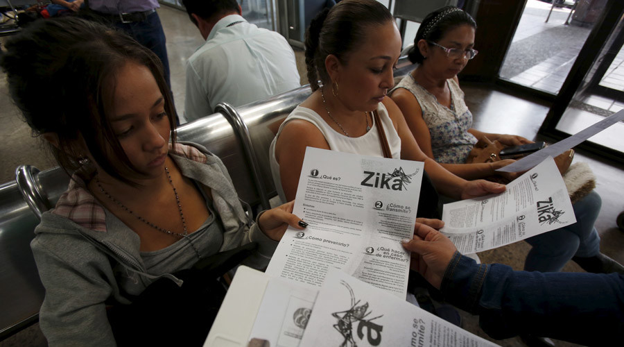 Colombian women listen as a health worker distributes information how to prevent the spread of the Zika virus at the transport terminal in Bogota Colombia