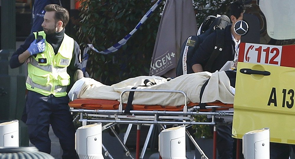 A victim is removed from the scene where shots were fired during a police search of a house in the suburb of Forest near Brussels Belgium