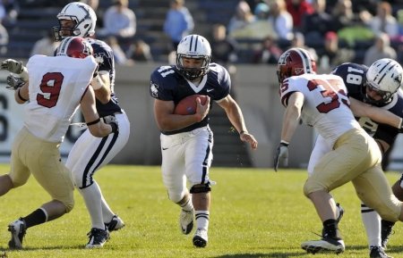 Yale's Alex Thomas runs up the middle for a first down between Harvard's Dan Minamide  and Bobby Schneider  in the first half of their NCAA football game at the Yale Bowl in New Haven Connecticut