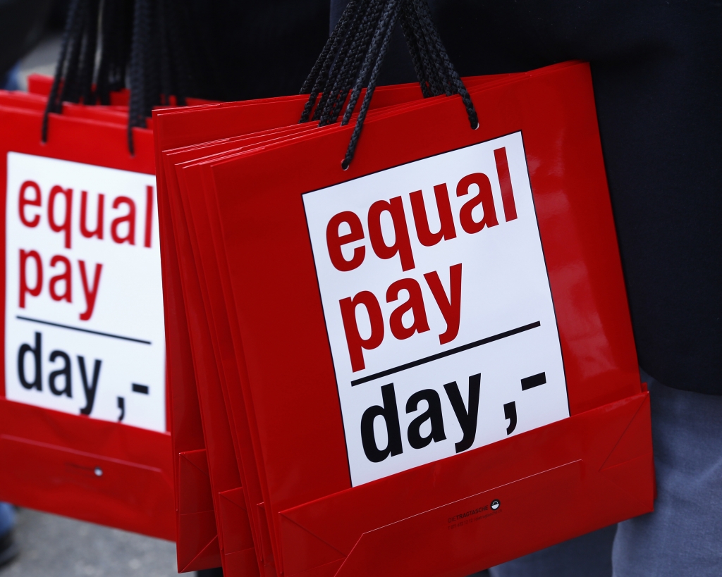 People carry bags reading'equal pay day during a protest a day before International Women's Day in Bern Germany