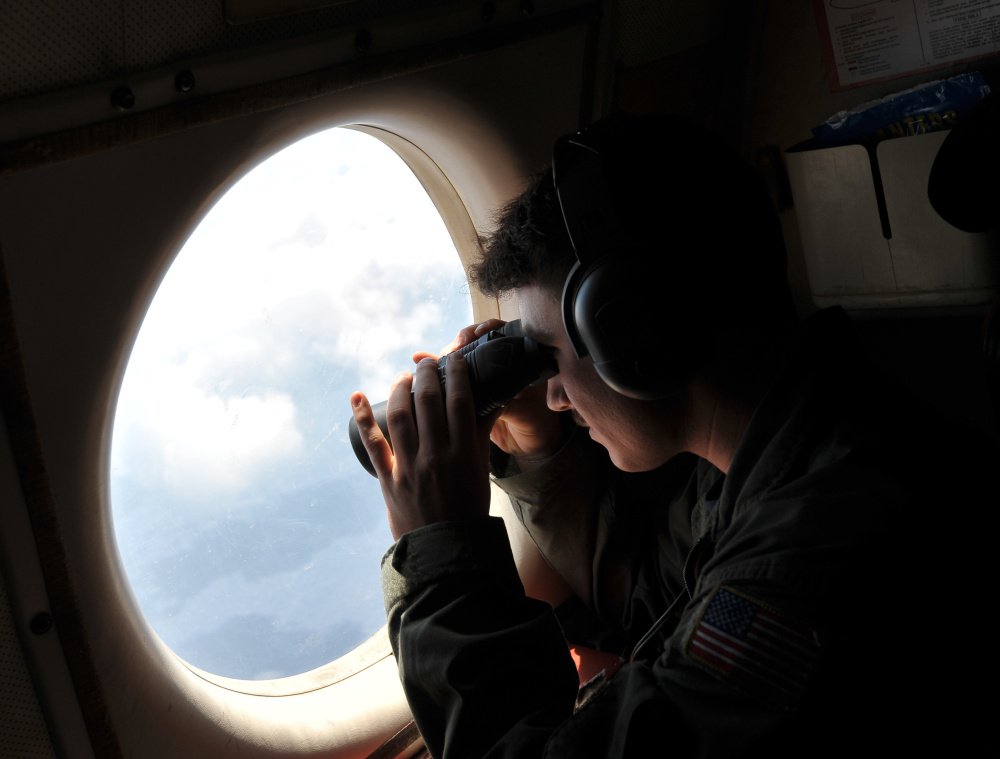 U.S. Navy Lt. j.g. Dylon Porlas looks out from a Lockheed P-3C Orion patrol aircraft Sunday over the area where the Egypt Air flight crashed