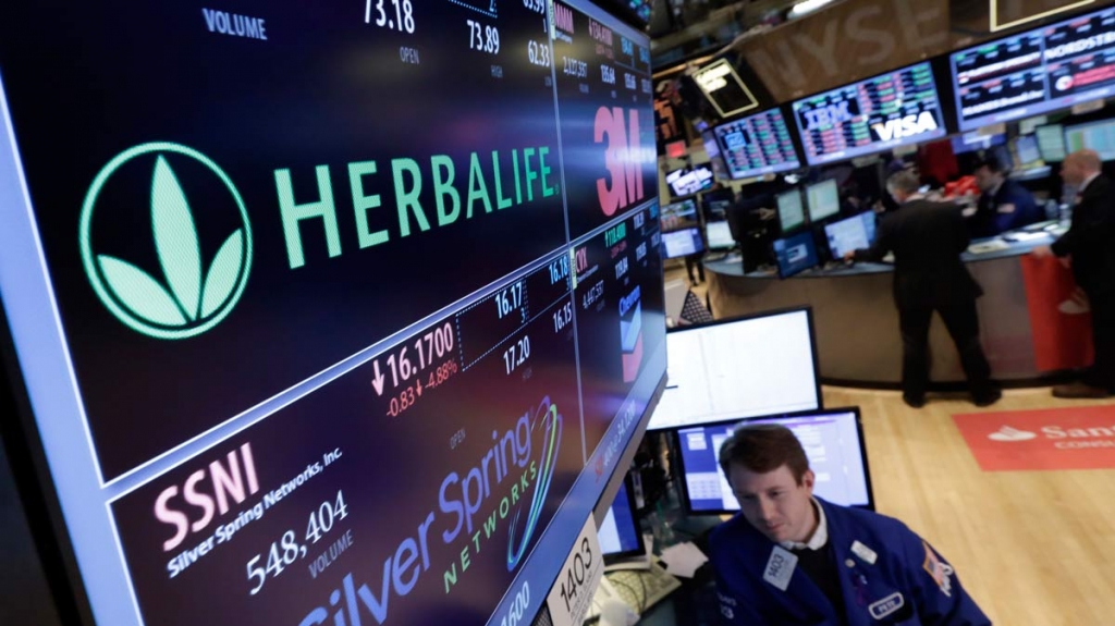 Specialist Peter Elkins foreground works at the post that handles Herbalife on the floor of the New York Stock Exchange