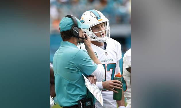 Miami Dolphins head coach Adam Gase speaks with quarterback Ryan Tannehill on the sidelines during the first half of an NFL football game against the Cleveland Browns Sunday Sept. 25 2016 in Miami Gardens Fla