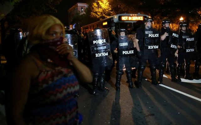 A demonstrator is greeted by police in riot gear while continuing to protest after curfew in Charlotte North Carolina US