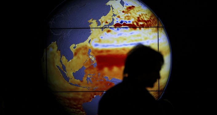 A woman walks past a map showing the elevation of the sea in the last 22 years during the World Climate Change Conference 2015 at Le Bourget near Paris France