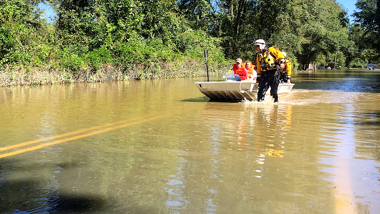 Rescuers from Dayton Ohio bring a group of stranded neighbors to dry land. Seated in the front is Wyatt Wood 16