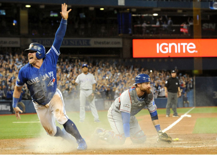 Toronto Blue Jays’ third baseman Josh Donaldson celebrates after scoring the winning run past Texas Rangers’ catcher Jonathan Lucroy in the 10th inning to give the Jays a three-game sweep in 2016 ALDS playoff at Rogers Centre Sunday. — Reut