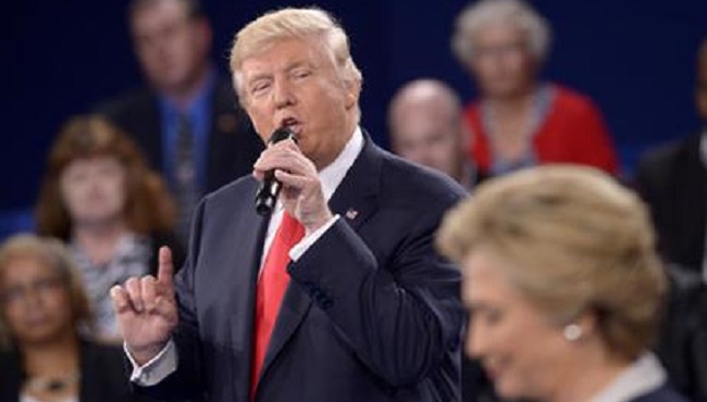 Republican presidential nominee Donald Trump speaks as Democratic presidential nominee Hillary Clinton listen during the second presidential debate at Washington University in St. Louis Sunday Oct. 9 2016