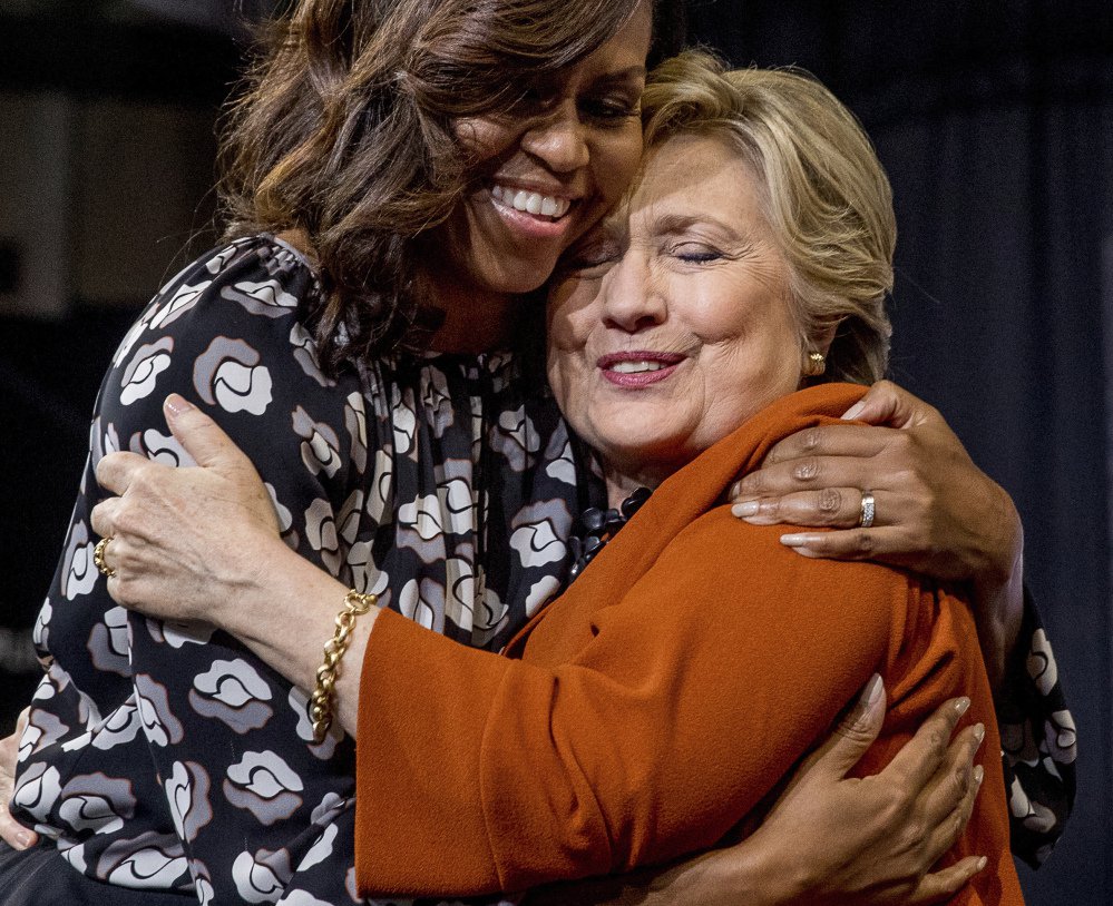 First lady Michelle Obama and Democratic presidential candidate Hillary Clinton hug after speaking at a campaign rally in Winston-Salem N.C. on Thursday. Even as they urged their audience to resist Republican attempts to convince them to stay home on El