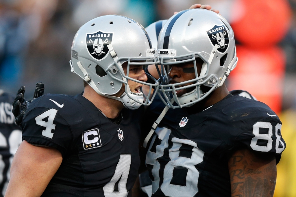 Clive Walford #88 of the Oakland Raiders celebrates with Derek Carr #4 after a 12-yard touchdown against the Carolina Panthers during their NFL game