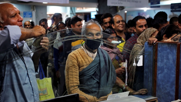 Customers wait for to exchange or deposit their old high denomination banknotes in Jammu India on Tuesday