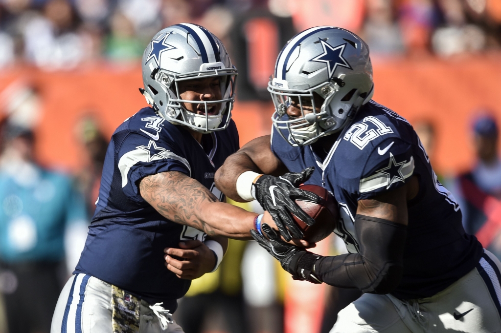 Dallas Cowboys quarterback Dak Prescott hands the ball to running back Ezekiel Elliott. ASSOCIATED PRESS