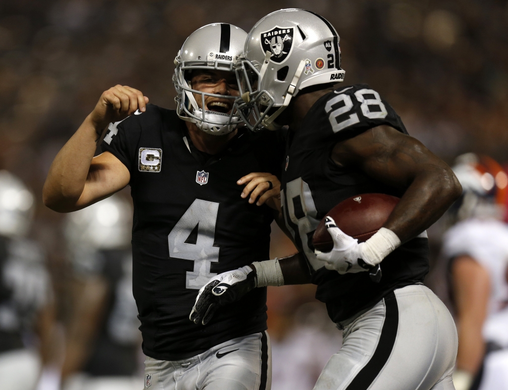 Oakland Raiders quarterback Derek Carr celebrates a touchdown by Oakland Raiders Latavius Murray in the second quarter of their NFL game against the Denver Broncos at the Coliseum in Oakland Calif. on Sunday Nov. 6 2016. (Nhat V. Meyer  Bay A