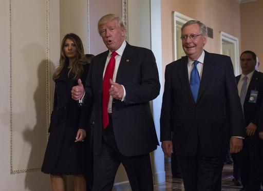 President-elect Donald Trump flanked by his wife Melania and Senate Majority Leader Mitch Mc Connell of Ky. gives a thumbs-up while walking on Capitol Hill in Washington Thursday Nov. 10 2016 after their meeting