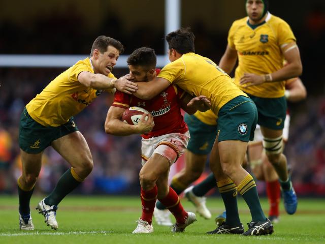 Rhys Webb of Wales is tackled by Bernard Foley and Nick Phipps of Australia during the