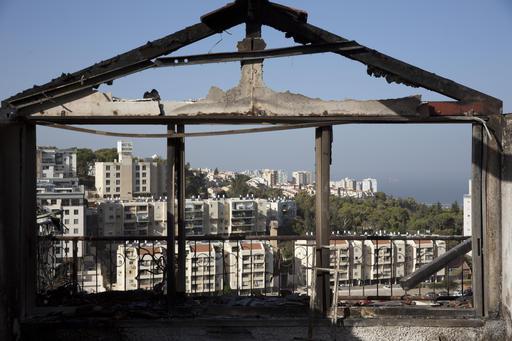 The Mediterranean sea and parts of the city can bee sen through a burned house following wildfires in Haifa Israel Friday Nov. 25 2016. Israeli firefighters reined in a blaze that had spread across the country's third-largest city and forced tens of