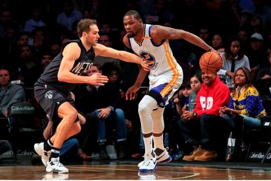 Golden State Warriors forward Kevin Durant is defended by Brooklyn Nets guard Bojan Bogdanovic during the first half of an NBA basketball game Thursday Dec. 22 2016 in New York