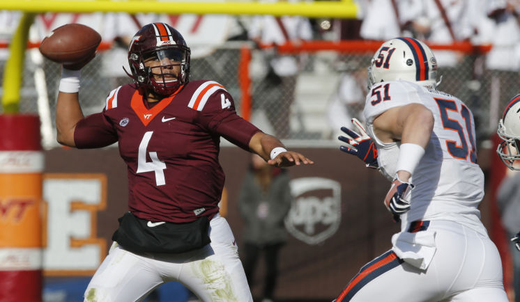 Virginia Tech quarterback Jerod Evans tosses a pass as Virginia linebacker Zach Bradshaw closes in during the first half of an NCAA college football game in Blacksburg Va. Saturday Nov. 26 2016. VASH130