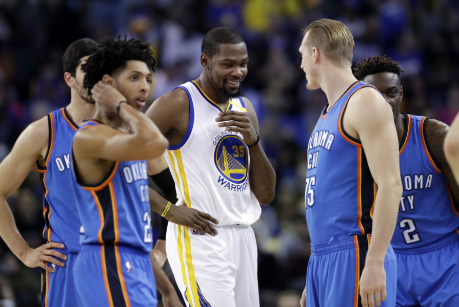 Golden State Warriors&#039 Kevin Durant smiles with members of the Oklahoma City Thunder during the first half of an NBA basketball game Wednesday Jan. 18 2017 in Oakland Calif